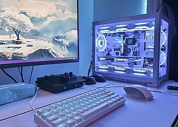 Guide: Hur man bygger en speldator - vitt chassi med glaspanel, RGB-fläktar, GPU och snyggt kablage, tillsammans med skärm, tangentbord och mus.