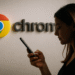 Google Chrome en Android y Seguridad - Mujer usando un teléfono móvil Android frente a un logo grande de Google Chrome en la pared, destacando la seguridad y navegación en Google Chrome en dispositivos Android.