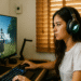 Type Soul Descubre el Discord y sube rápido de nivel - Alt text: "Mujer concentrada jugando en computadora el videojuego Type Soul con auriculares de gaming, enfocada en subir rápido de nivel y descubrir el Discord del juego."