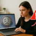 Cómo detectar qué ralentiza Windows en tu PC - Mujer usando un portátil con señal de alerta, investigando cómo detectar qué ralentiza Windows en su PC para solucionar la lentitud y optimizar el rendimiento.