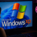 Modo compatibilidad Windows 11: monitor con Windows 11 mostrando el logo de Windows XP, ilustrando ejecutar programas antiguos en PC.
