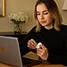 Cómo emparejar AirPods con Chromebook: persona abre el estuche de AirPods y los conecta por Bluetooth a un portátil HP.