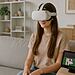 Control cerebral Apple - Mujer joven usando visor de realidad virtual en el sofá mientras controla una tablet con la mente, ilustrando el nuevo BCI menos invasivo de Apple para control cerebral.