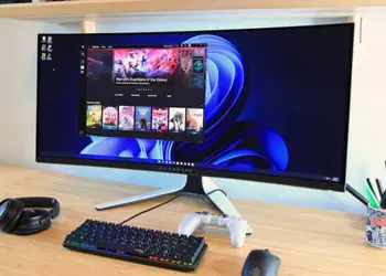 Top monitores gaming: monitor ultrawide curvo Alienware en escritorio, con teclado mecánico, auriculares y mando, ideal para setup de juegos en PC.