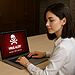 Virus MEMZ - Woman using a laptop showing a red virus alert screen, illustrating MEMZ virus malware infection warning and cybersecurity threat on a Windows PC.