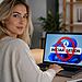 Cuenta local Windows 11; Mujer usando portátil con Windows 11 mostrando pantalla de “Iniciar sesión” bloqueada, ilustrando cómo crear una cuenta local en Windows 11 y evitar iniciar sesión con Microsoft.