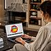 Programas desinstalados Windows 11 - Mujer usando un portátil para recuperar programas desinstalados en Windows 11.